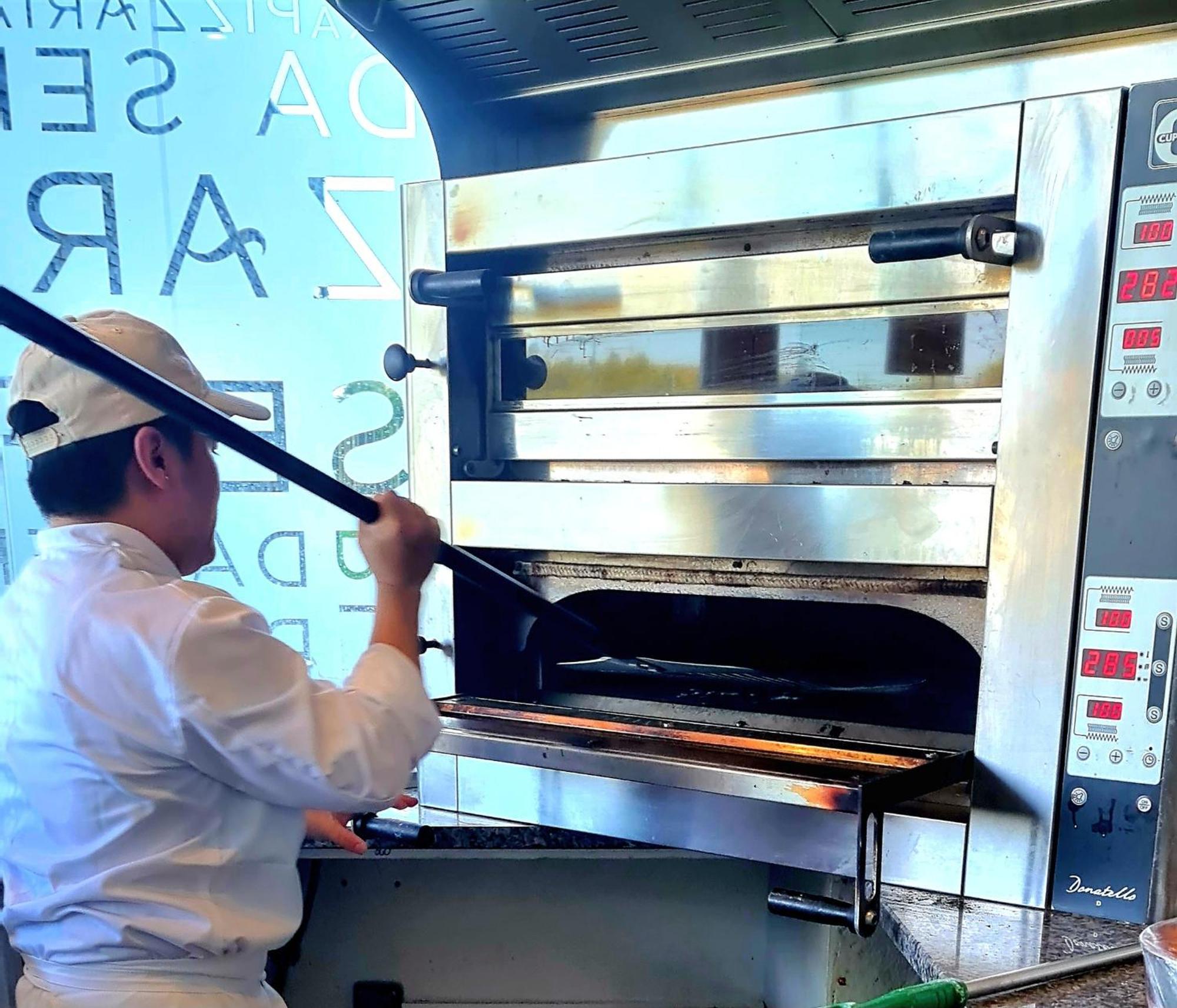 몬치크 리조트 앤 스파 몬시크 외부 사진 A pizzaiolo baking a pizza in a wood-fired oven